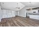 An open-concept living room with wood flooring, white cabinets, and a vaulted ceiling at 919 Salt Pl., Murrells Inlet, SC 29576