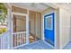 View of a screened-in porch next to a bright blue front door and freshly painted porch at 919 Salt Pl., Murrells Inlet, SC 29576