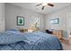 Well-lit bedroom with a blue patterned bedspread, desk, and wall art at 933 Jackline Place # 101, Murrells Inlet, SC 29576