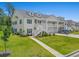 Inviting exterior view of a two-story condo with white siding, green grass, and a well-maintained lawn at 933 Jackline Place # 101, Murrells Inlet, SC 29576
