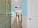 Hallway with coastal blue paint, white wainscoting, and tile flooring leading into a bright living area at 9400 Shore Dr. # 722, Myrtle Beach, SC 29572