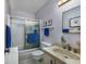 Bathroom featuring a shower-tub combination, toilet, marble-like sink, and vertically striped wallpaper at 10200 Lake Shore Dr. # 16, Myrtle Beach, SC 29572