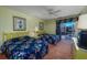 Bright bedroom featuring two beds, floral patterns, and a sliding glass door to the outside at 10200 Lake Shore Dr. # 16, Myrtle Beach, SC 29572