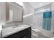 Bathroom featuring granite countertops, dark cabinets, a vanity sink, a mirror, and a bathtub with a shower at 1107 Haden Place, Calabash, NC 28467