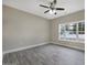 This bedroom features a ceiling fan, modern flooring, and a large window providing natural light and neighborhood views at 1107 Haden Place, Calabash, NC 28467