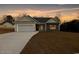 Charming single-Gathering home with a two-car garage and manicured lawn at dusk at 1107 Haden Place, Calabash, NC 28467
