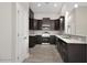 Modern kitchen featuring dark wood cabinets, granite countertops, and stainless steel appliances at 1107 Haden Place, Calabash, NC 28467