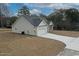 New construction home exterior showcasing the back of the house with a driveway and landscaping at 1107 Haden Place, Calabash, NC 28467