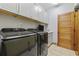 Well-equipped laundry room with modern washer and dryer units, white cabinets, and tiled floor at 136 Da Gullah Way # A, Pawleys Island, SC 29585