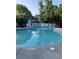 This is a community pool surrounded by chairs and green foliage at 136 Da Gullah Way # A, Pawleys Island, SC 29585