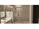 Bathroom showcasing vanity with quartz countertop and a spacious shower with a glass door at 1407 Gooseneck Place # 202, Murrells Inlet, SC 29576