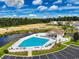 Aerial view of a community pool, clubhouse, and recreation area by the lake at 1407 Gooseneck Place # 202, Murrells Inlet, SC 29576