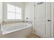Bright bathroom includes tub, shower, window, tiled floor and white door at 1487 Lanterns Rest Rd. # 4, Myrtle Beach, SC 29579