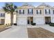 Attractive townhome with manicured landscaping, including a palm tree and white stone accents on the driveway at 1487 Lanterns Rest Rd. # 4, Myrtle Beach, SC 29579