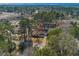 Scenic aerial view of a charming home nestled among lush greenery, mature trees, and a tranquil pond in a desirable neighborhood at 1917 Candy Ln., Surfside Beach, SC 29575