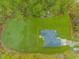 A private home and backyard viewed aerially amid green space surrounded by dense trees at 1930 W Homewood Rd., Conway, SC 29526