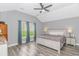 Bright main bedroom features a vaulted ceiling, wood-look floors, and natural light from large windows at 1930 W Homewood Rd., Conway, SC 29526