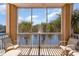 The screened balcony features seating and a view of palm trees surrounding a pond at 2180 Waterview Dr. # 727, North Myrtle Beach, SC 29582