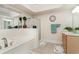 Bright bathroom features a shower, bathtub, decorative clock, and ample vanity storage space at 2180 Waterview Dr. # 727, North Myrtle Beach, SC 29582
