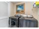 Well-lit laundry room with front load washer and dryer, with a beach themed picture at 2180 Waterview Dr. # 727, North Myrtle Beach, SC 29582