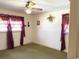 A simple bedroom with neutral walls and windows adorned with unique, ornate curtains at 2501 Main St., Loris, SC 29569