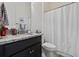 Bathroom with black vanity, granite countertop, sink, toilet, and shower with white patterned shower curtain at 2794 Howard Ave. # D, Myrtle Beach, SC 29577