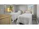Bright bedroom featuring two twin beds with white linens, light gray walls, and hardwood flooring at 306 74Th Ave. N # 105, Myrtle Beach, SC 29572