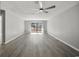 Bright living room with gray plank flooring, a ceiling fan, and access to an outdoor balcony at 306 74Th Ave. N # 105, Myrtle Beach, SC 29572