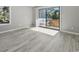 Sunlit living room with gray plank flooring and access to an outdoor balcony with bright sunshine at 306 74Th Ave. N # 105, Myrtle Beach, SC 29572