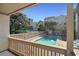 View from a balcony of a refreshing community pool with lounge chairs and nearby landscaping at 306 74Th Ave. N # 105, Myrtle Beach, SC 29572
