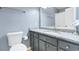 Bathroom with gray cabinets, granite countertops, a large mirror, and a toilet at 3308 S Ocean Blvd. # 2-A, North Myrtle Beach, SC 29582