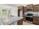 Bright kitchen features granite countertops, stainless steel appliances, and brown cabinets at 342 Barn Owl Way, Conway, SC 29527