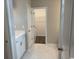 Well-lit bathroom featuring a vanity with storage, tiled floors, and an open doorway to a walk-in closet at 360 Kapalua Loop, Little River, SC 29566