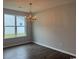 Bright dining room with a decorative chandelier, hardwood floors, and a large window overlooking the outdoors at 360 Kapalua Loop, Little River, SC 29566