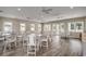 Bright community room with hardwood floors, multiple tables, chairs, and ceiling fans at 416 Kapalua Loop, Little River, SC 29566