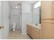 Well-lit bathroom features a vanity with storage, neutral tile floor, and a combined shower and toilet area at 4247 Villas Dr. # 406, Little River, SC 29566