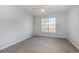 Bright bedroom featuring plush gray carpet, a ceiling fan, and a window providing natural light at 4247 Villas Dr. # 406, Little River, SC 29566
