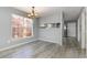 Dining room with wood-look floors, a modern light fixture and large window at 4247 Villas Dr. # 406, Little River, SC 29566