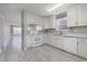 Well-lit kitchen with stainless steel sink, white appliances and view to the living room at 4247 Villas Dr. # 406, Little River, SC 29566