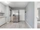 Open kitchen with stainless steel refrigerator, white cabinets, and washer and dryer in closet at 4247 Villas Dr. # 406, Little River, SC 29566