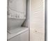 Laundry area featuring a stacked washer and dryer adjacent to a closet with louvered doors at 4247 Villas Dr. # 406, Little River, SC 29566