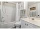 Bathroom with shower-tub combination, white vanity, and wallpaper in a cheerful plaid pattern at 4405 Eastport Blvd. # D-8, Little River, SC 29566