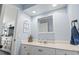 Light and airy bathroom featuring white vanity, decorative mirror, and calming blue walls at 4405 Eastport Blvd. # D-8, Little River, SC 29566