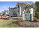 Exterior view of condo building with Spinnaker Cove signage and well-maintained landscaping at 4405 Eastport Blvd. # D-8, Little River, SC 29566
