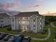 Exterior view of condo building featuring multiple balconies, lush landscaping, and ample parking at 4405 Eastport Blvd. # D-8, Little River, SC 29566