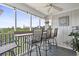 Inviting screened porch featuring a bar, ceiling fan, and comfortable seating with peaceful outdoor views at 4405 Eastport Blvd. # D-8, Little River, SC 29566
