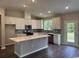 Bright kitchen featuring white cabinets, a spacious center island, stainless steel appliances, and views to the backyard at 453 Kapalua Loop, Little River, SC 29566