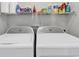 Convenient laundry area equipped with a washer, a dryer, and a storage shelf for laundry supplies organization at 4861 Luster Leaf Circle # 204, Myrtle Beach, SC 29577