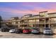 Multi-story condo building with private balconies, complemented by ample parking and vibrant sunset backdrop at 501 Maison Dr. # E20, Myrtle Beach, SC 29572