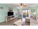 Bright living room with a large TV and sliding door access to the outdoor balcony at 501 Maison Dr. # E20, Myrtle Beach, SC 29572